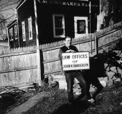1980 the late Mattie Fairweather, electrician, holding Vanderlyn law office sign from early 1900s.